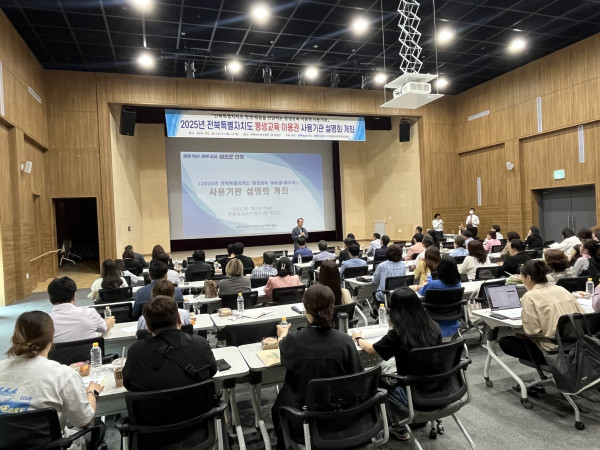 2025년 전북특별자치도 평생교육이용권 사용자 기관 설명회 현장. 회의실 형태의 강당에서 많은 참석자들이 발표자의 설명을 듣고 있으며, 스크린에는 “사용기관 설명회 개회”라는 문구가 표시되어 있다.